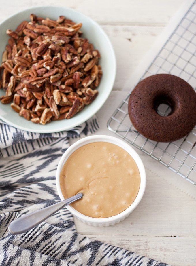 These turtle donuts start with a chocolate decadent donut, topped with caramel glaze and sprinkled with chopped pecans. | ahappyfooddance.com